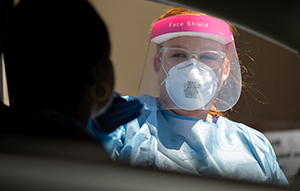 Nurse at car window swabbing for covid-19
